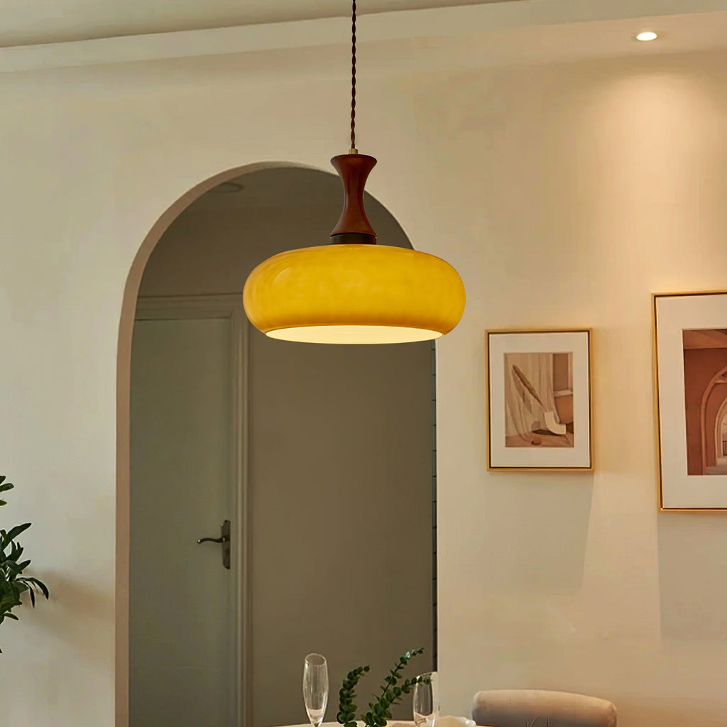 Suspension baladeuse en verre dans un couloir voûté décoré de cadres