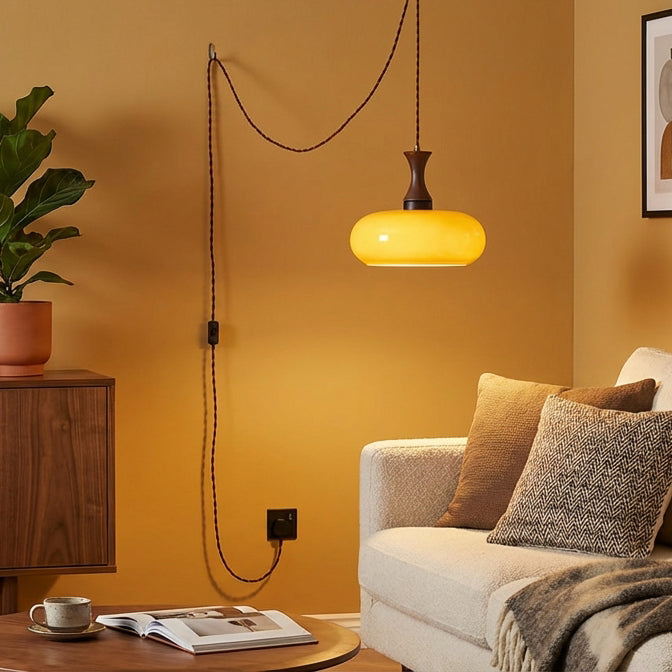 Suspension baladeuse en verre suspendue au-dessus d'un canapé, mur terracotta