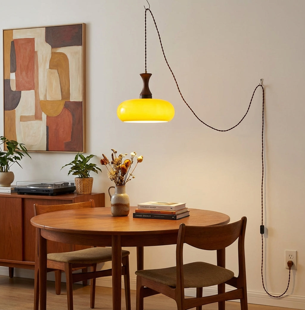 Suspension baladeuse en verre au-dessus d'une table ronde en bois clair