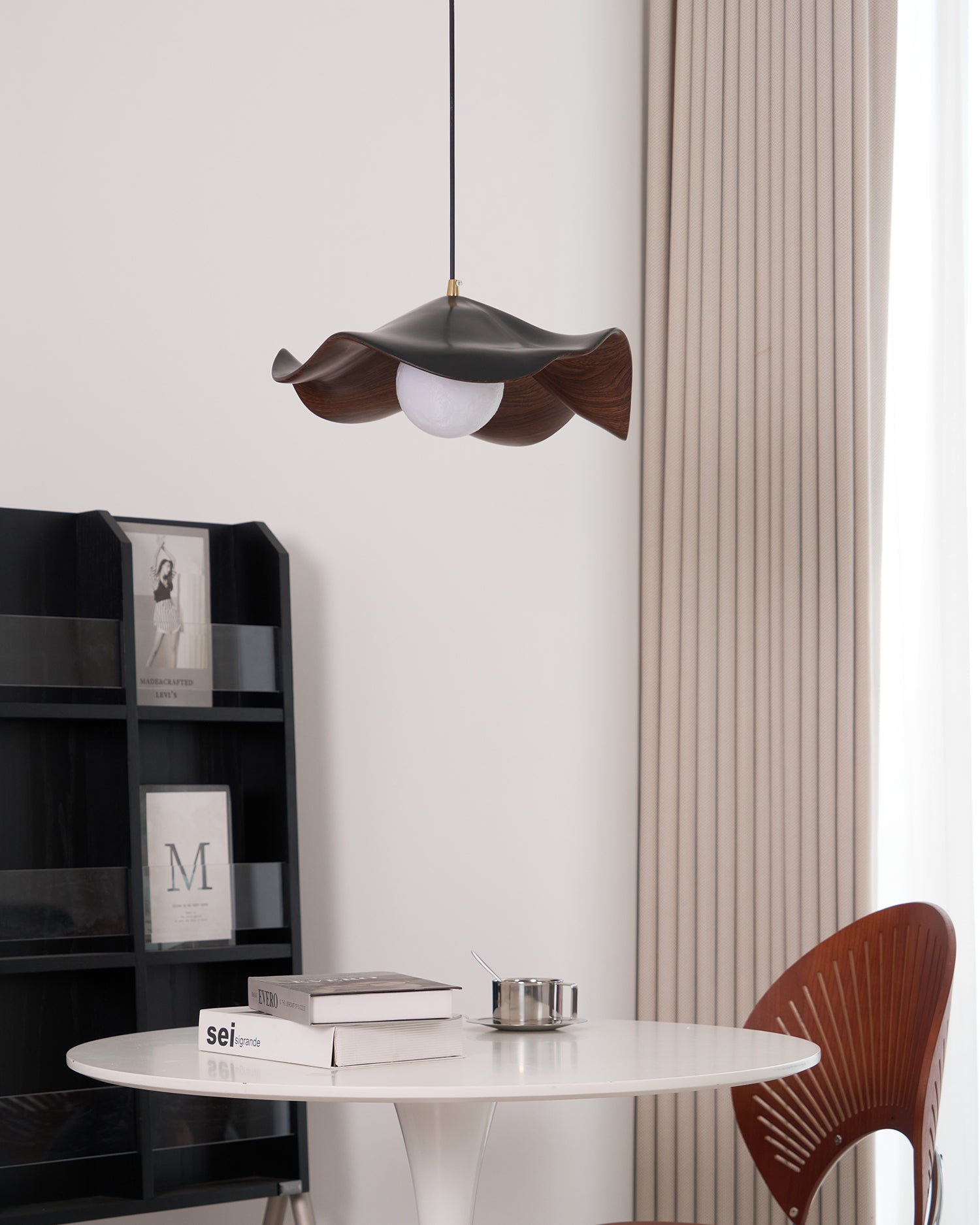 Suspension design organique finition noyer au-dessus d'une table ronde blanche