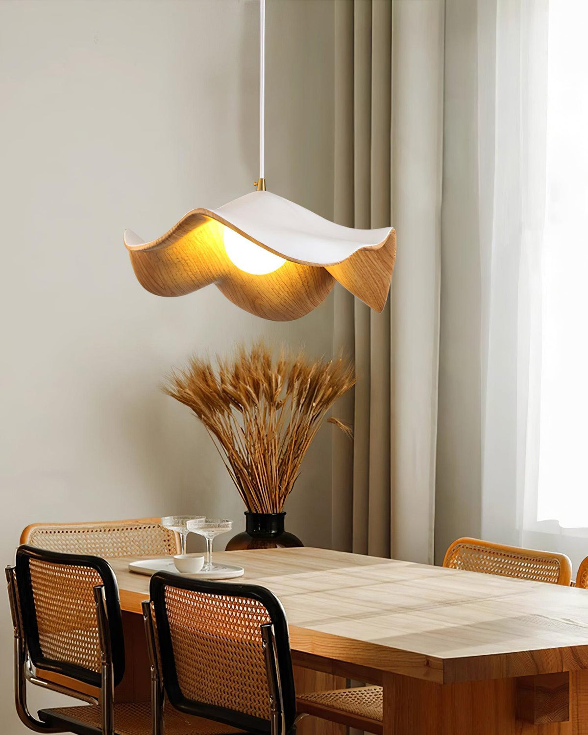 Suspension design organique finition bois clair au-dessus d'une table à manger
