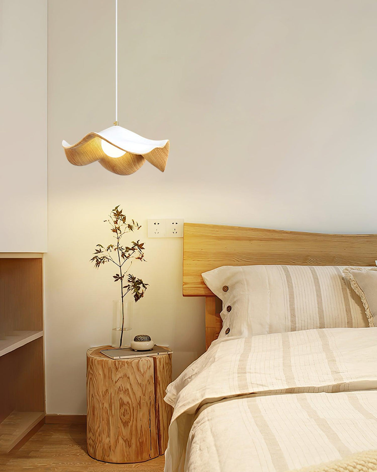 Suspension design organique finition bois clair au-dessus d'un chevet dans une chambre