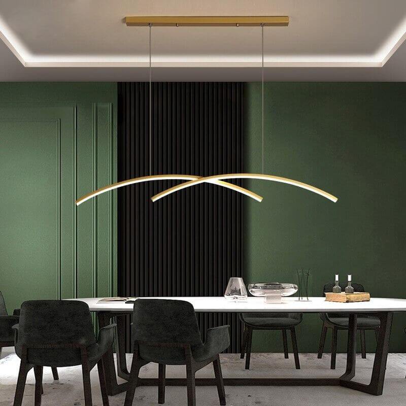 Suspension LED double arc dorée dans une salle à manger aux murs verts