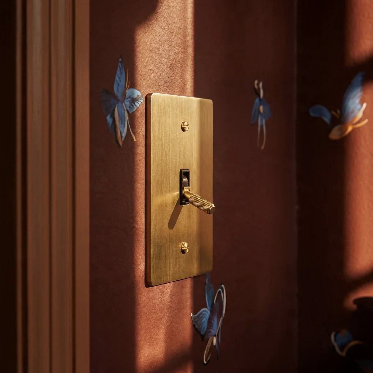 Interrupteur vintage dore sur un mur sombre decore