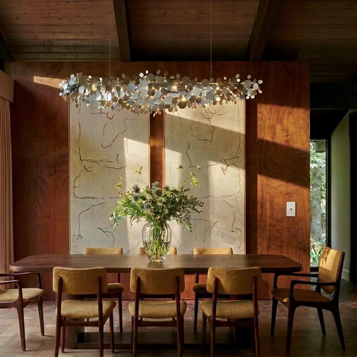 Variateur de lumière en laiton dans une salle à manger en bois avec suspension florale