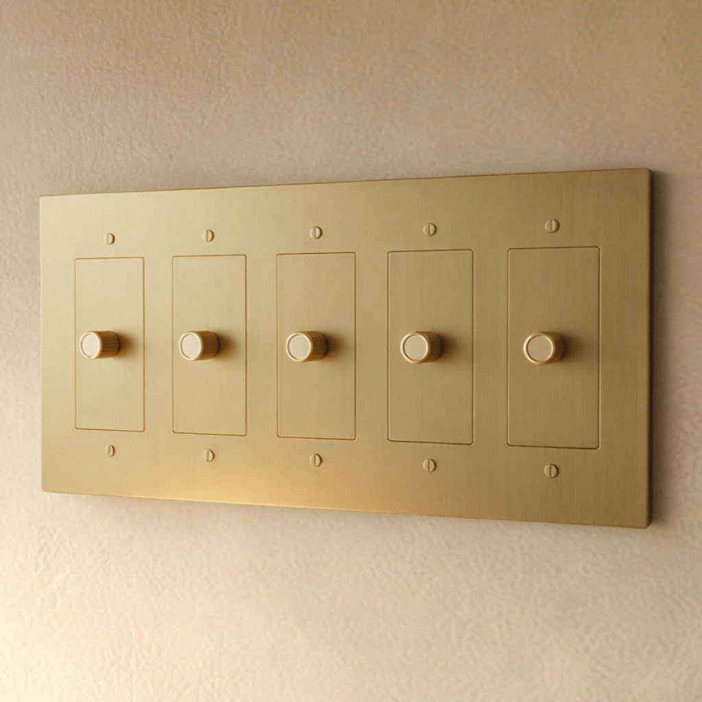 Variateur de lumière en laiton doré 5 postes sur un mur beige