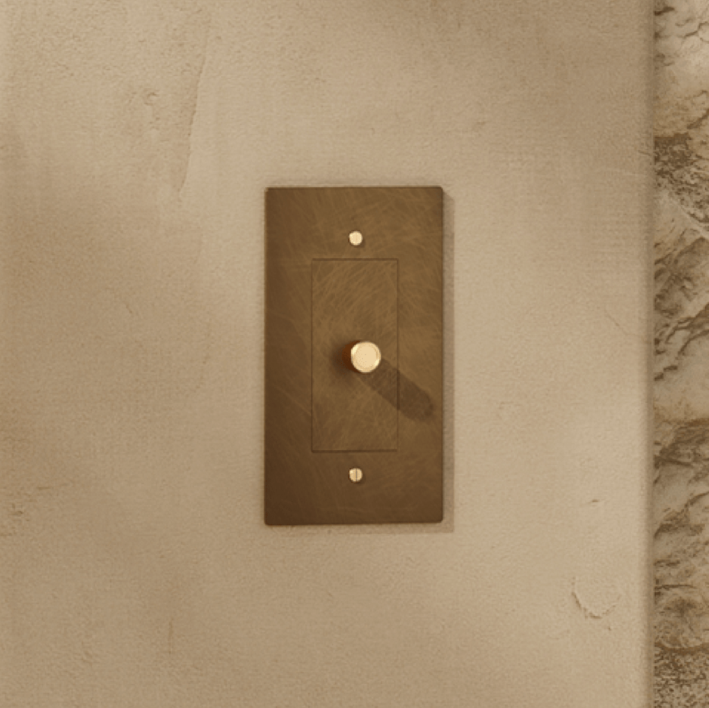 Gros plan sur la texture patinée d'un variateur de lumière en laiton vieilli
