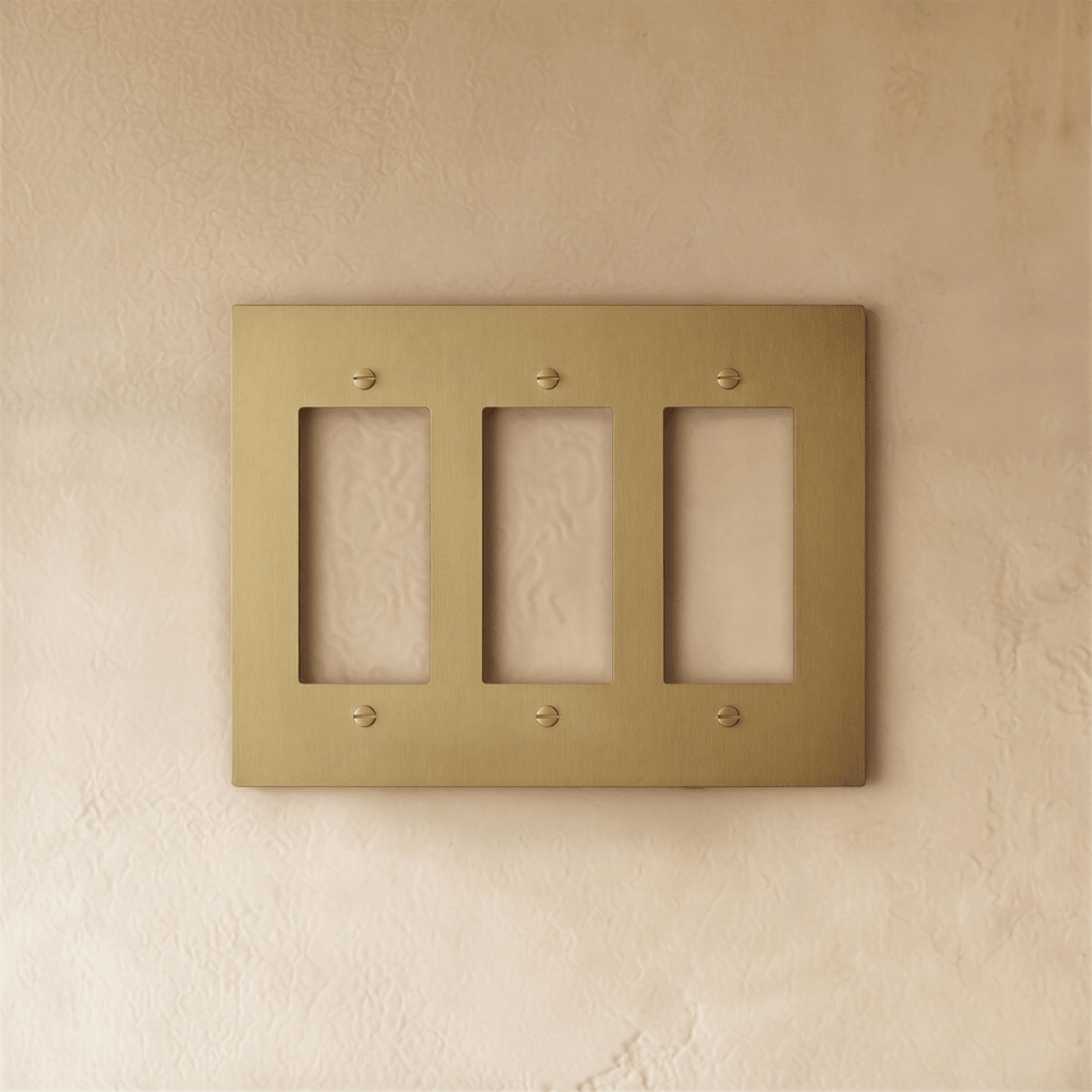 Plaque interrupteur en laiton 3 postes sur mur clair
