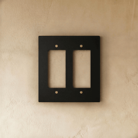 Plaque interrupteur noir et laiton 2 postes sur mur clair