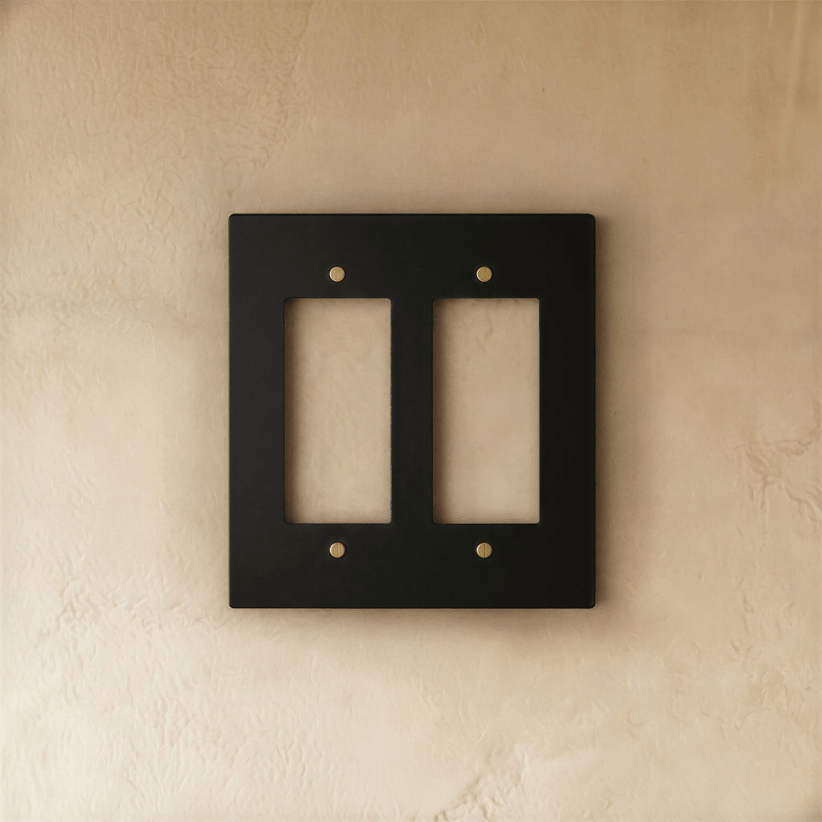 Plaque interrupteur noir et laiton 2 postes sur mur clair