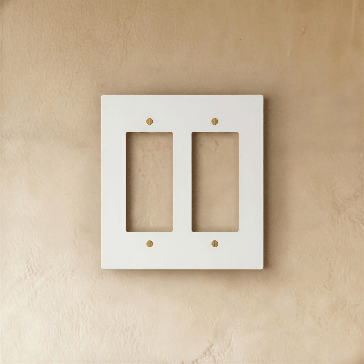 Plaque interrupteur blanc et laiton 2 postes sur mur clair