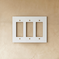 Plaque interrupteur blanc et laiton 3 postes sur mur clair