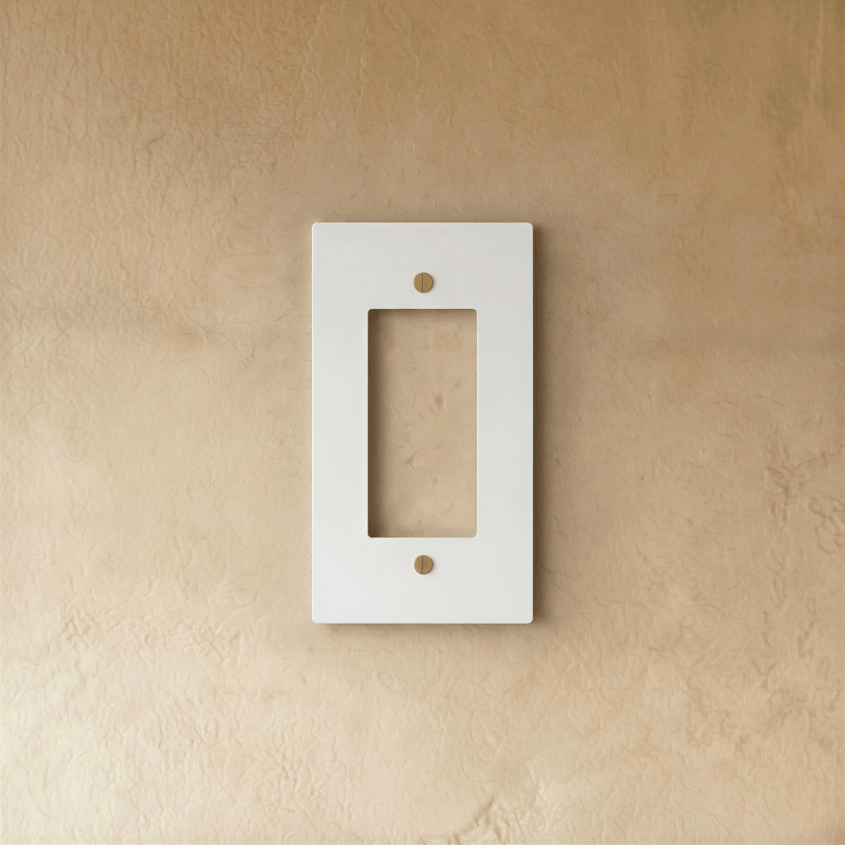 Plaque interrupteur blanc et laiton 1 poste fixée sur un mur beige