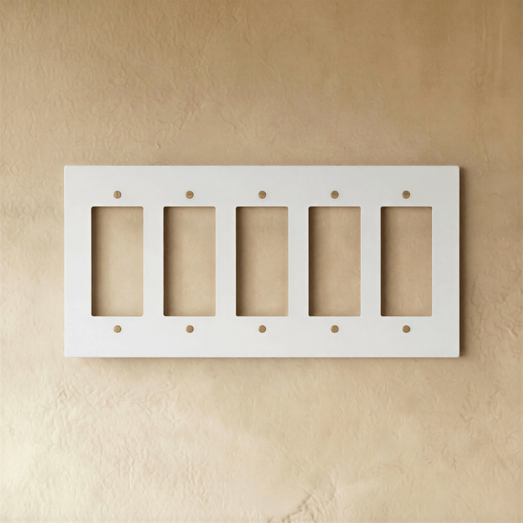 Plaque interrupteur blanc et laiton 5 postes sur mur clair