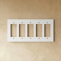 Plaque interrupteur blanc et laiton 5 postes sur mur clair