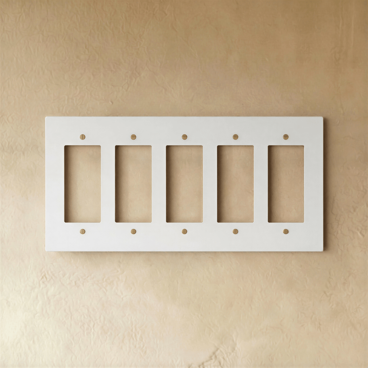 Plaque interrupteur blanc et laiton 5 postes sur mur clair