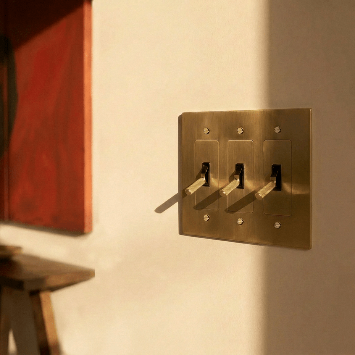 Interrupteur laiton 3 postes sur mur avec oeuvre d art