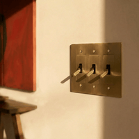 Interrupteur laiton 3 postes sur mur avec oeuvre d art